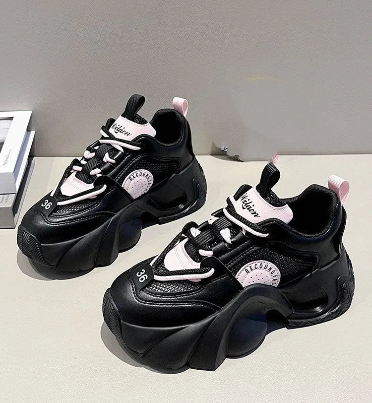 Women's pink casual sneakers with a thick sole, cross-strap detail, and lace-up closure on a white background.