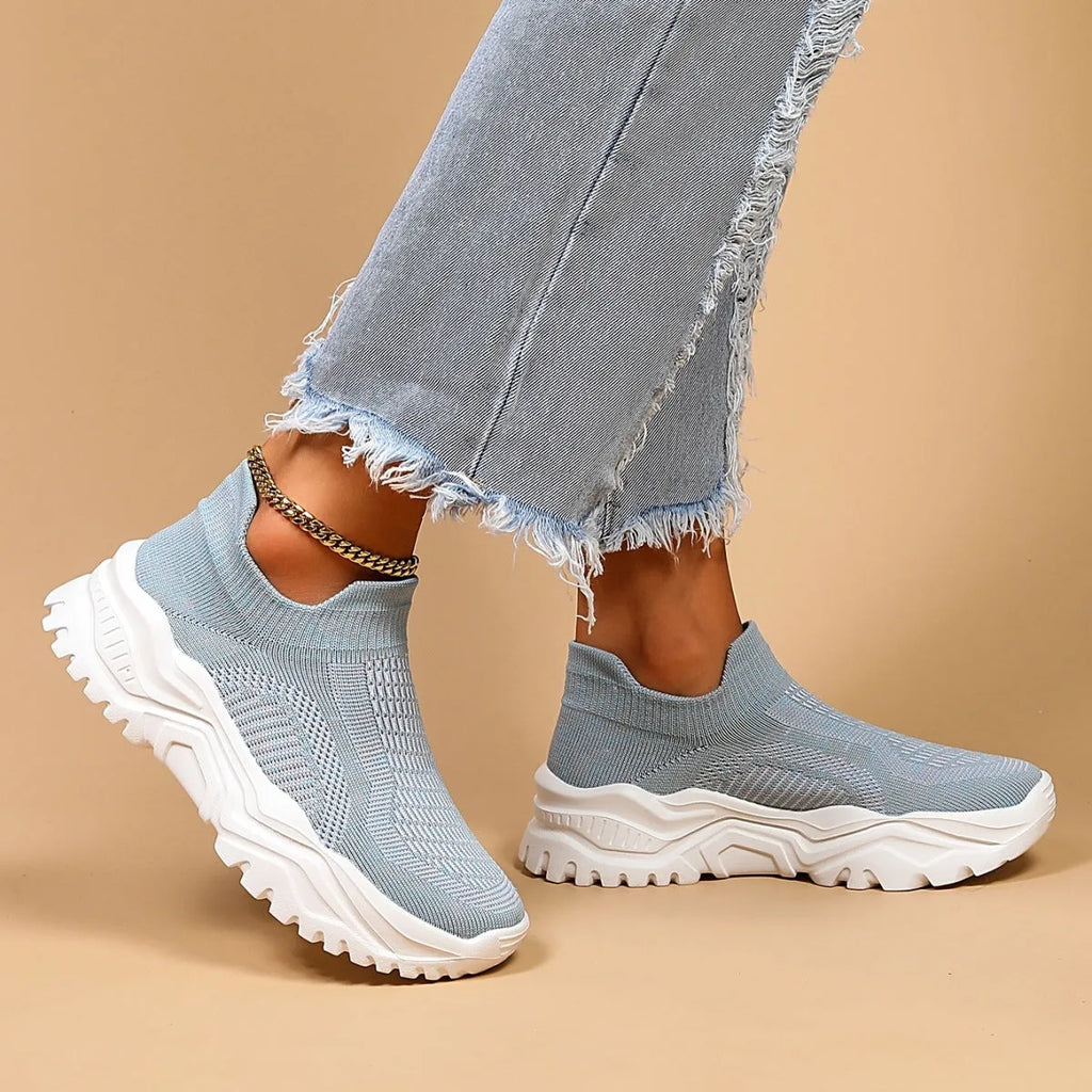Women's light blue mesh slip-on sports shoes with a rounded toe and mid heel.