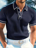Man modelling a striped loose-fit short-sleeved polo shirt in a dark blue colour.
