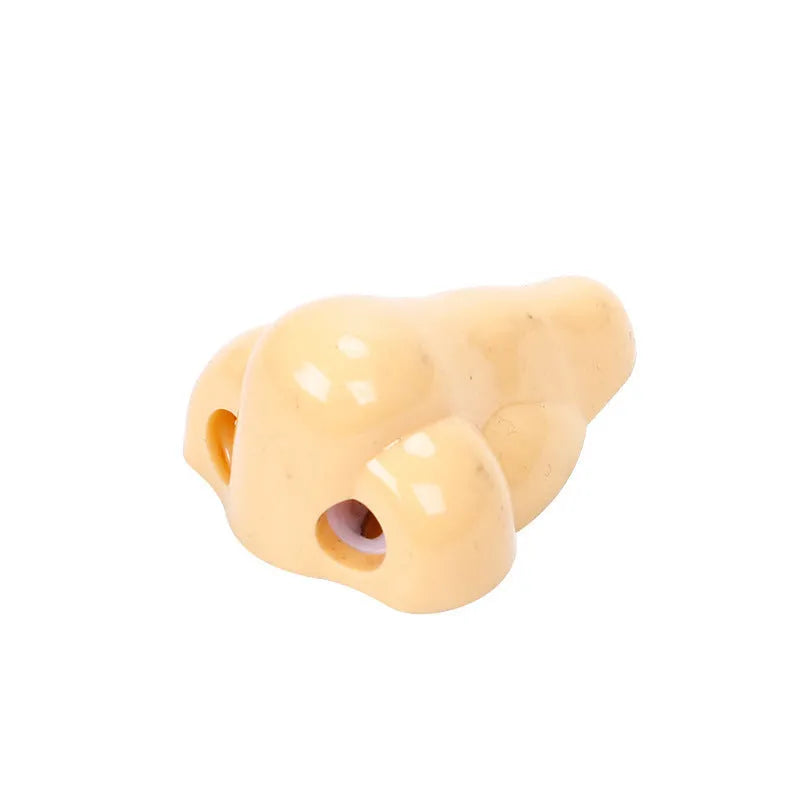 Flesh-coloured plastic manual pencil sharpener with a geometry shape, shown next to a pencil for scale.