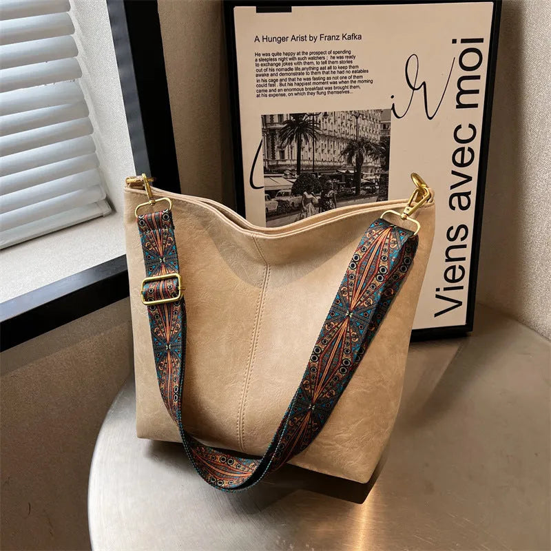 Women's large capacity crossbody bucket bag in PU with nylon lining, available in multiple colours, includes zipper change bag and phone pocket