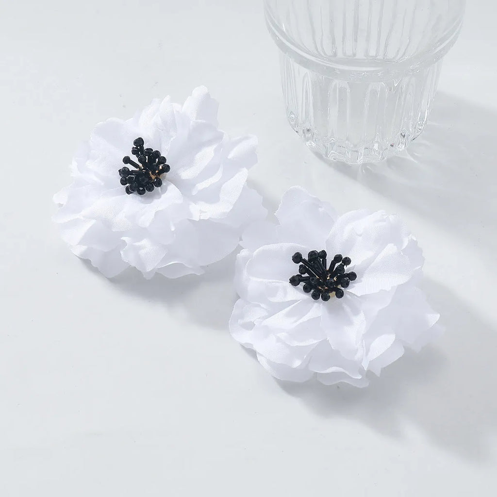 Hand-woven white plastic resin flower earrings for women fashion OL style on display