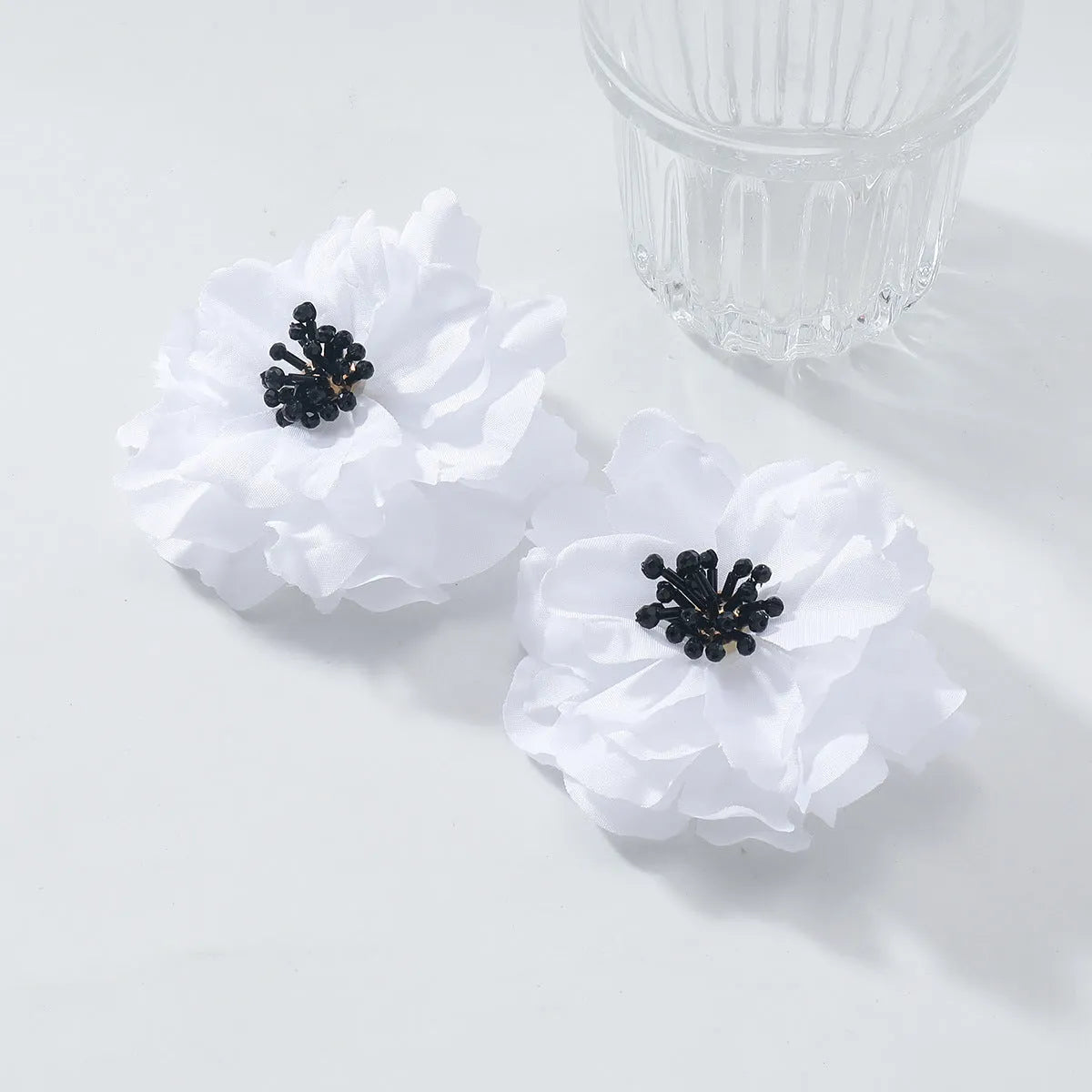 Hand-woven white plastic resin flower earrings for women fashion OL style on display