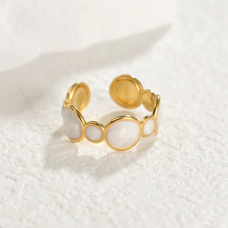 Silver geometric ring with adjustable opening on a plain background.