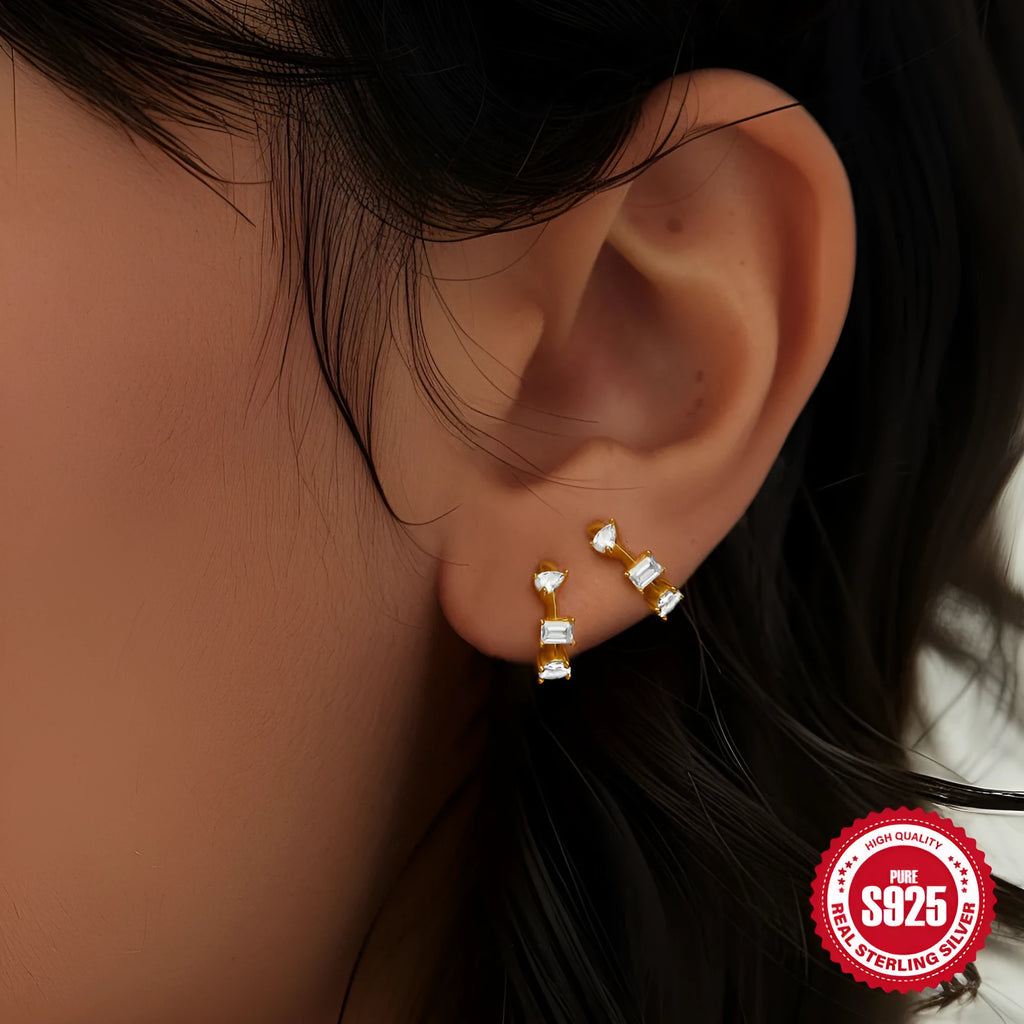 A pair of small round sterling silver geometric stud earrings with a classic diamond detail on a plain background.