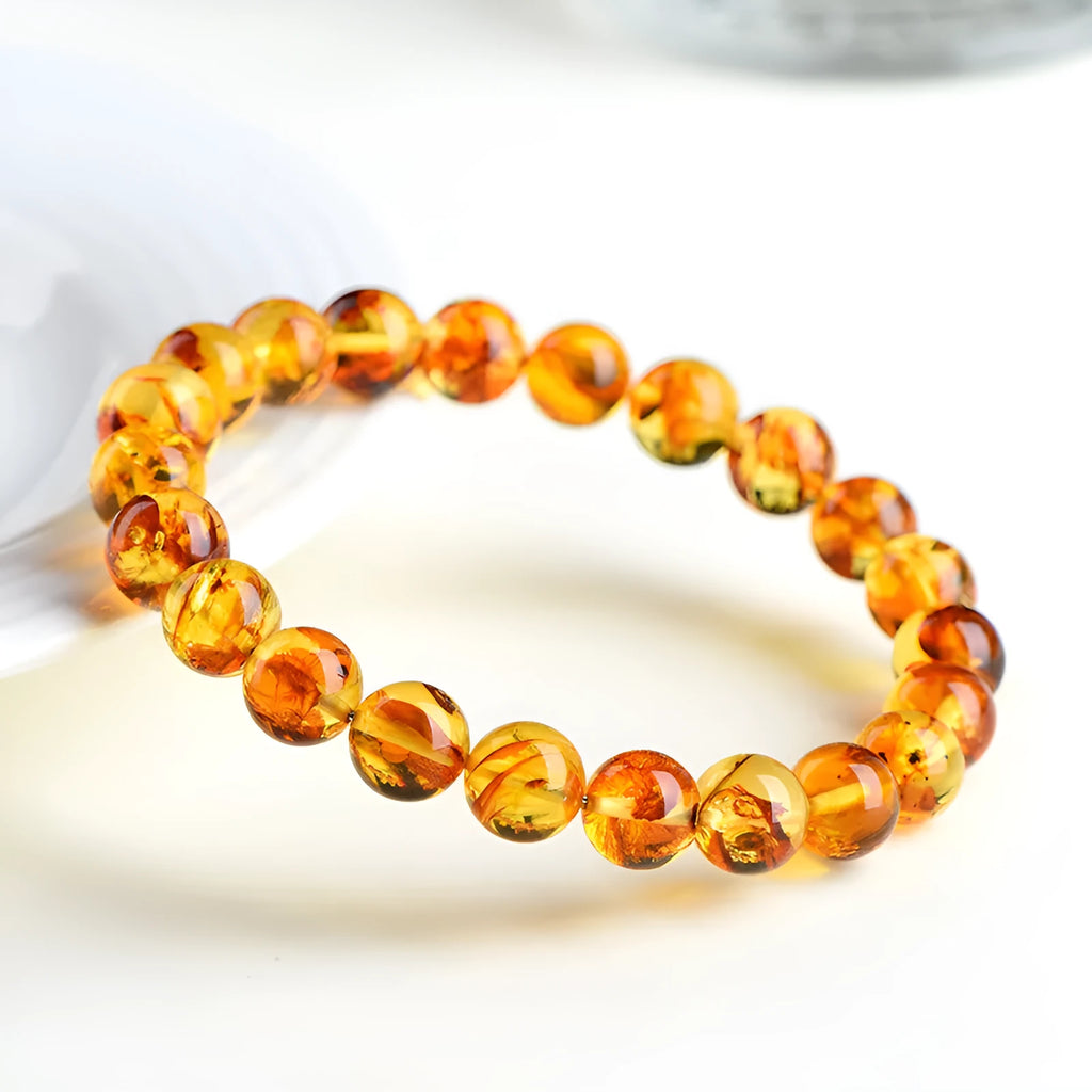 Natural yellow piebald amber bracelet with geometric design on a wrist.