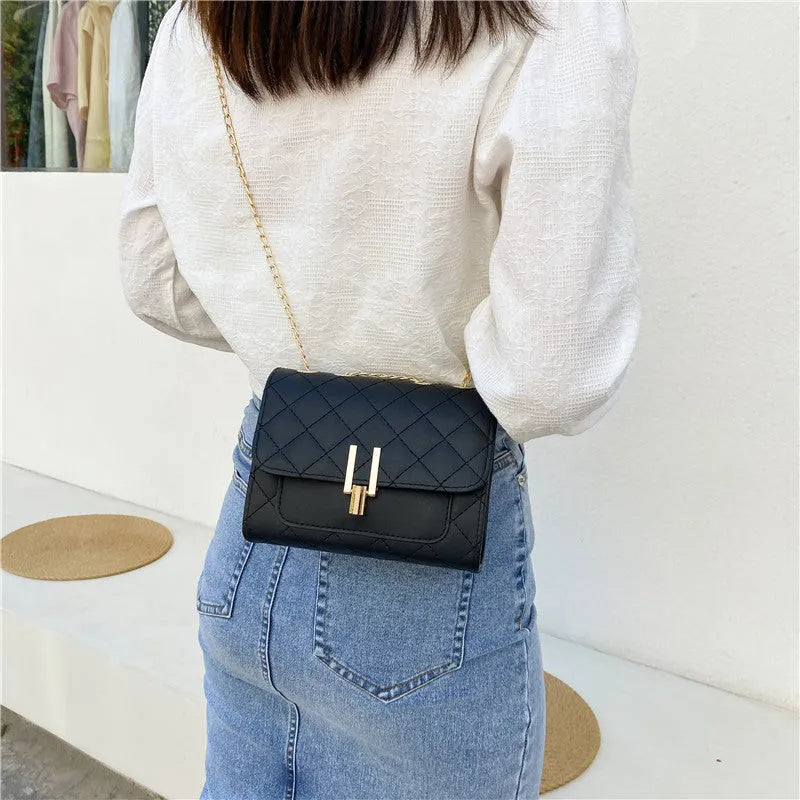 Women's white diamond lattice chain crossbody bag showing adjustable strap and structured shape