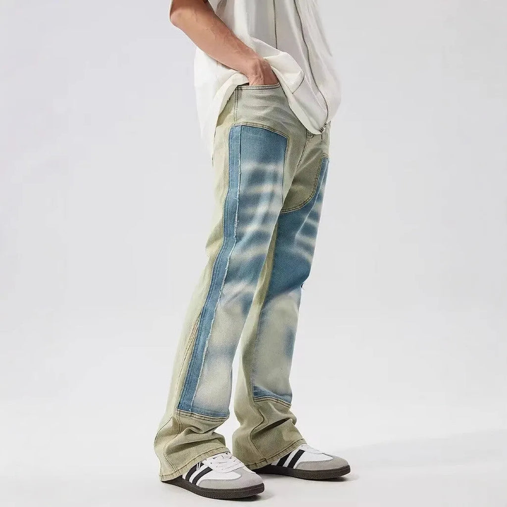Yellow and blue patchwork distressed denim jeans with a mid-rise waist and zip fly.