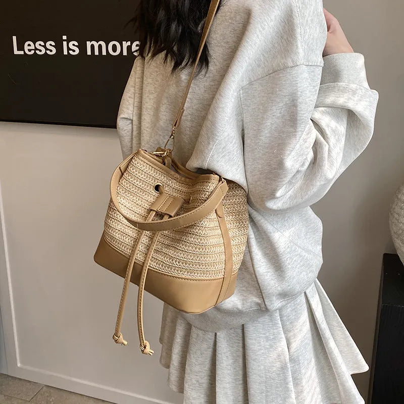 Woven straw women's crossbody bucket bag in brown colour showing horizontal square shape