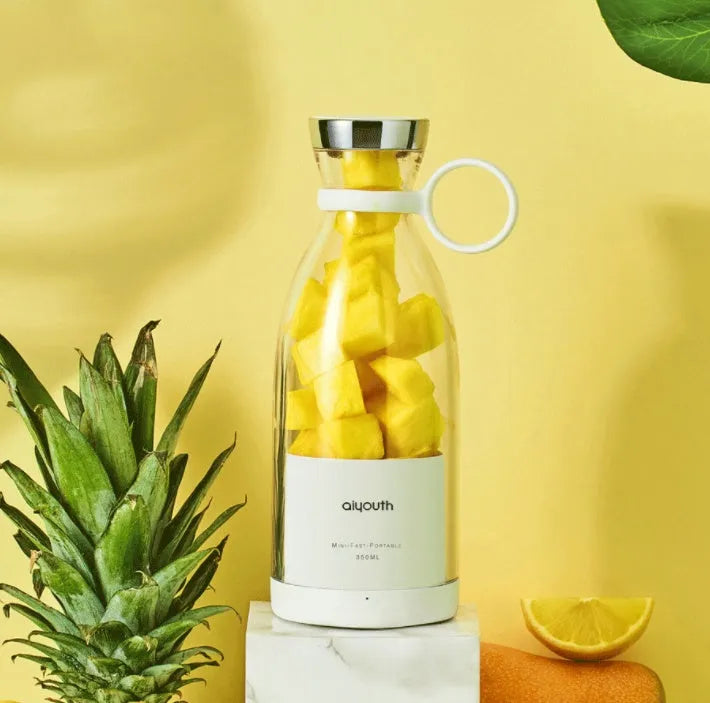 Pink and white handheld portable mini juicer with USB charging cable.