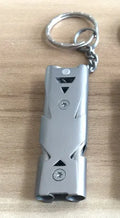 Compact metal keychain whistle with black lanyard on a keyring for outdoor emergency use