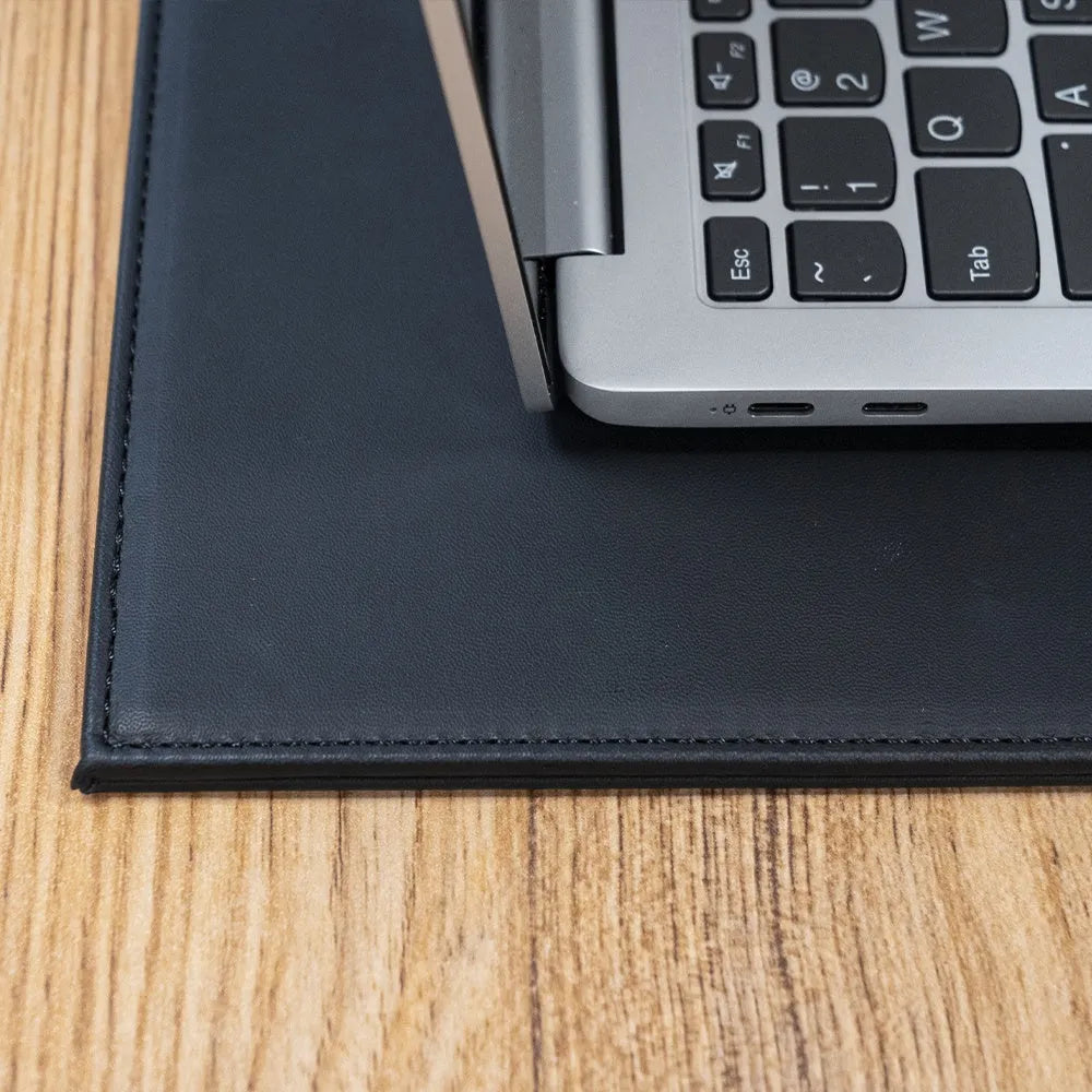 Durable heat-insulating anti-radiation laptop pad in black, black gold, blue, and green colour options on a desk.