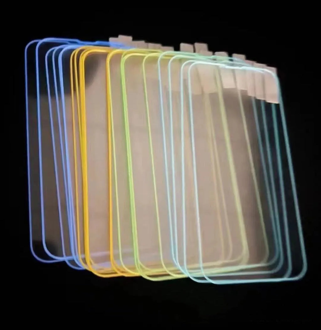 Fluorescent tempered glass screen protector glowing on an iPhone 13, showing pink luminous edge and precise camera cutout.