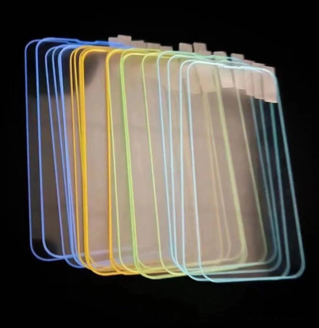 Fluorescent tempered glass screen protector glowing on an iPhone 13, showing pink luminous edge and precise camera cutout.