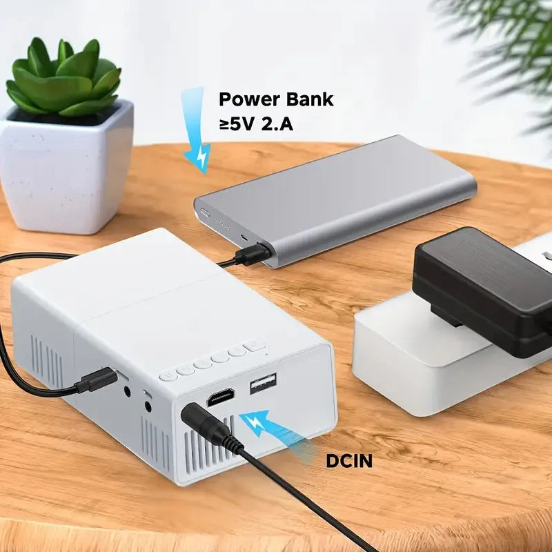 Compact white M100 mini LED home projector with remote control on a table.