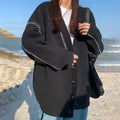 Women's loose black knitted cardigan coat with long sleeves.