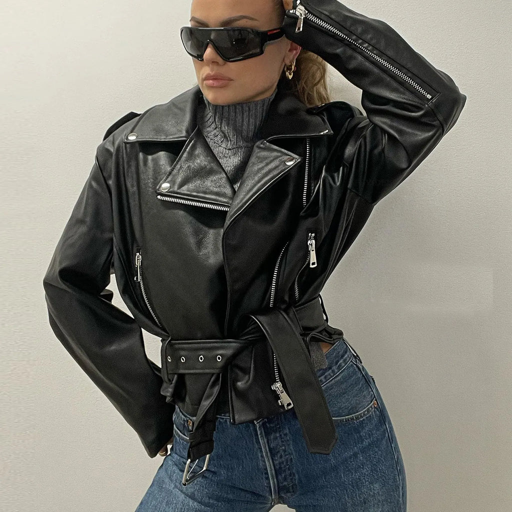 Black punk-style cropped jacket with a Peter Pan collar and a detachable waist belt on a hanger.