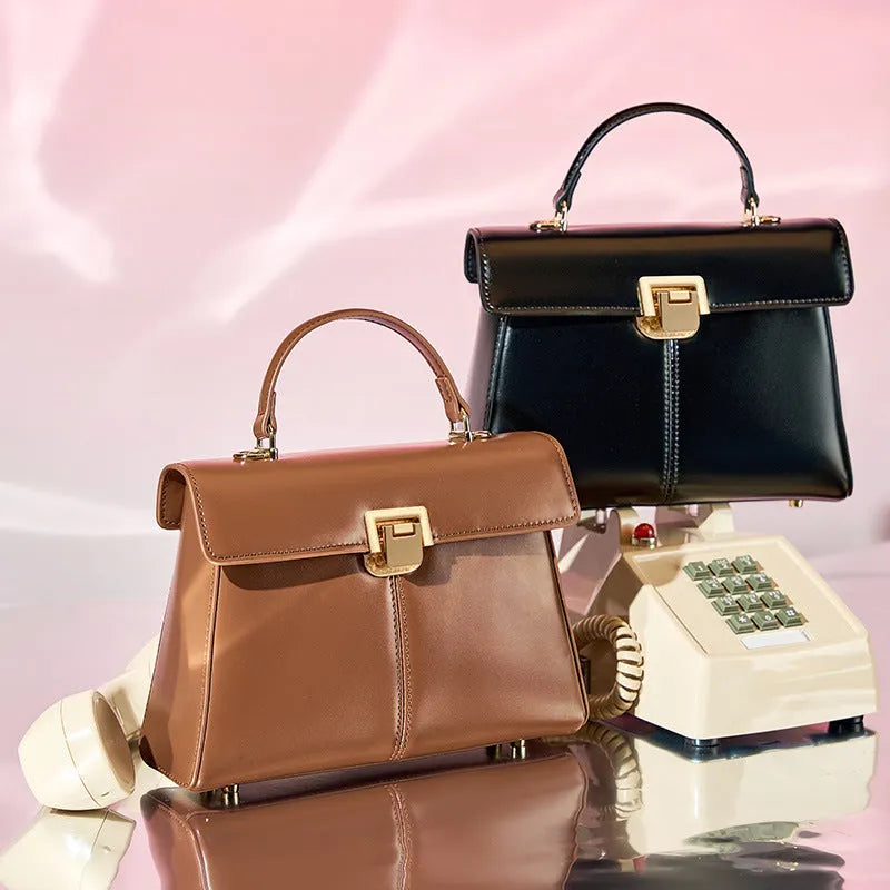 Women's black genuine vachette leather shoulder bag with clasp closure and 120cm strap.