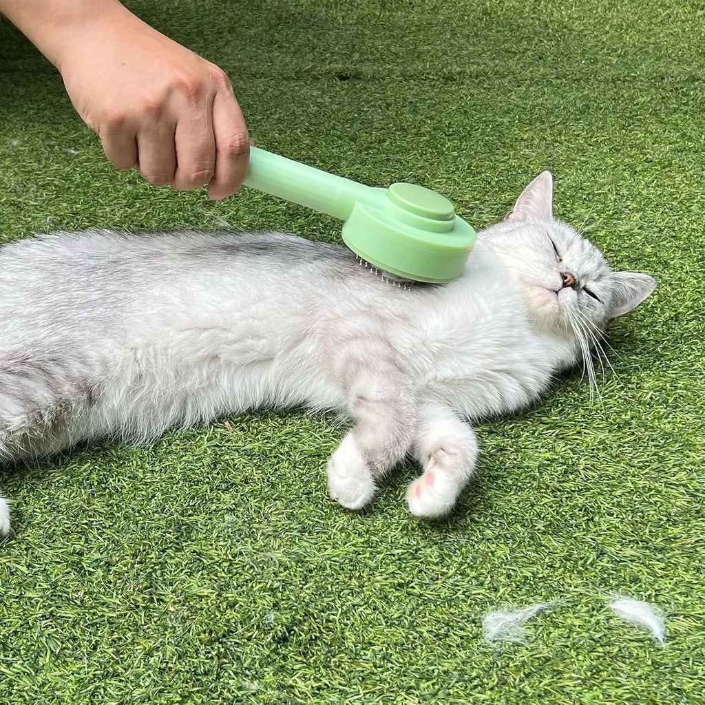 Green and yellow pet grooming brush with stainless steel comb for cats and dogs, showing hanging loop and curved teeth design