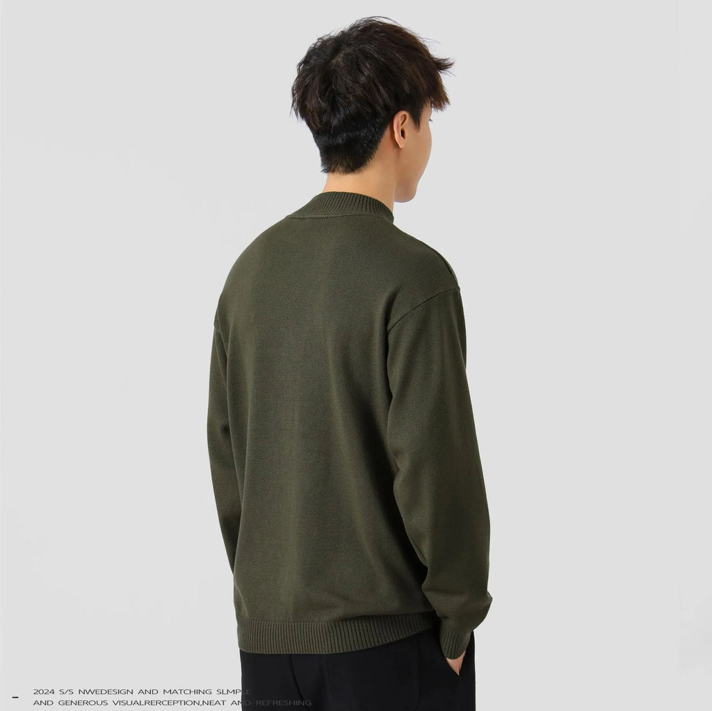 Man wearing a loose-fit long-sleeve solid colour sweater in a casual setting.