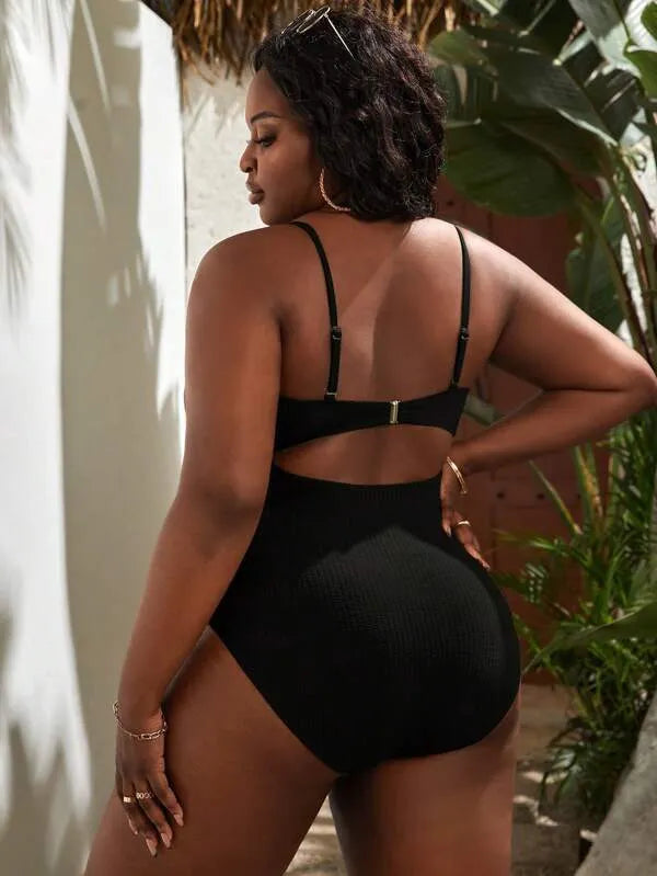 Plus size women's black slimming one-piece swimsuit with triangle sling design