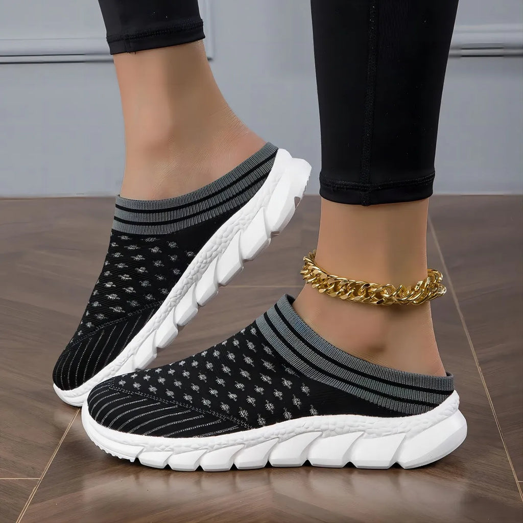 Women's black Flyknit semi-slipper casual shoe with striped pattern and hollow-out design on a white background.