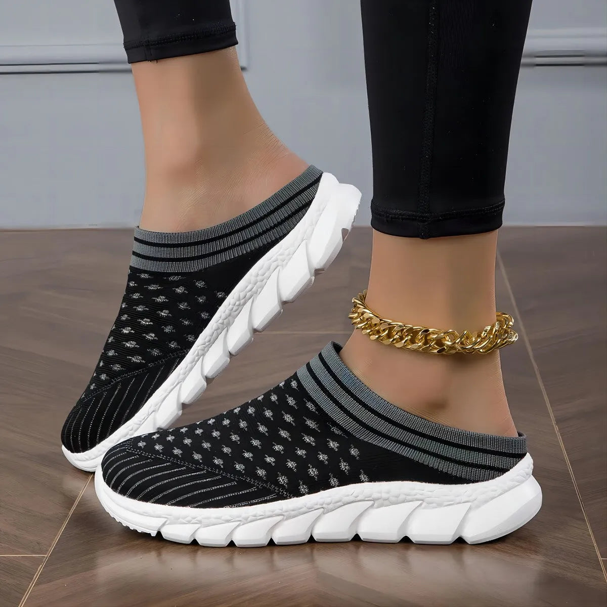 Women's black Flyknit semi-slipper casual shoe with striped pattern and hollow-out design on a white background.