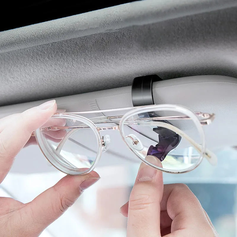 Black plastic car sunshade clip for holding glasses and cards, measuring 6.5 by 2.3 centimetres.