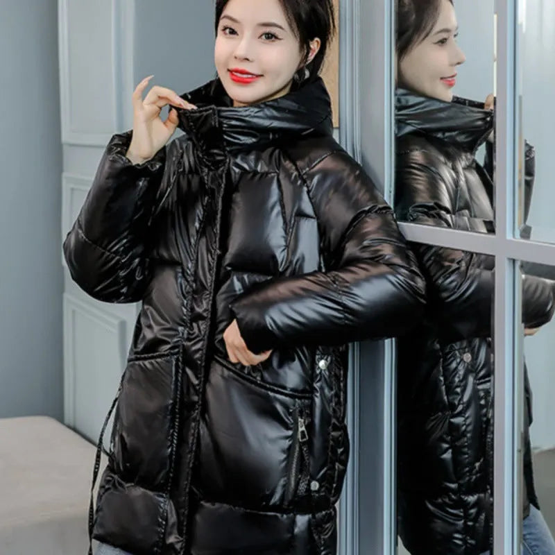 Green loose-fit women's hooded winter jacket with long sleeves on a hanger