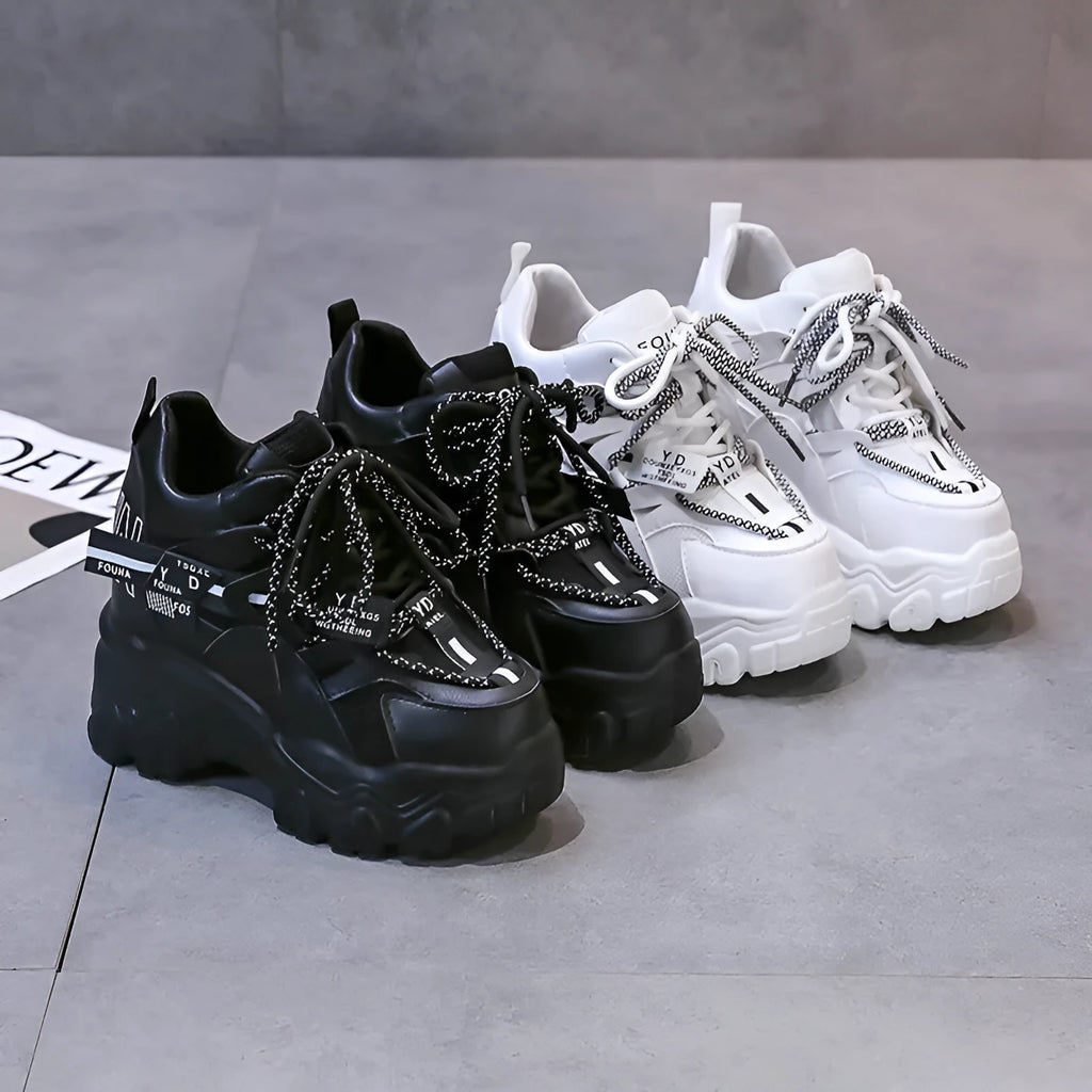 White women's low-top mesh platform sports shoe with a cross strap and rubber sole.