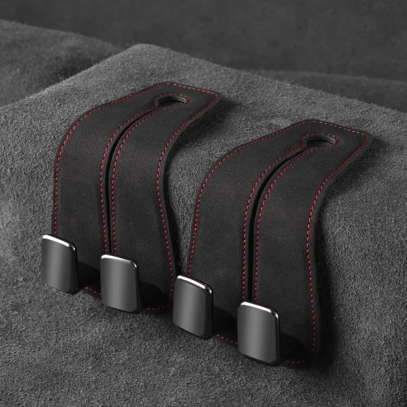 Black alloy car seat hook with suede covering attached to a grey car seatback.
