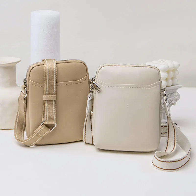 Solid colour small PU crossbody shoulder bag for mobile phones on a strap.