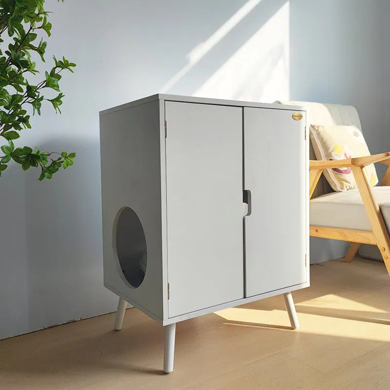 Wooden cat nest cabinet in ivory finish, with front opening for cat access, on a wooden floor
