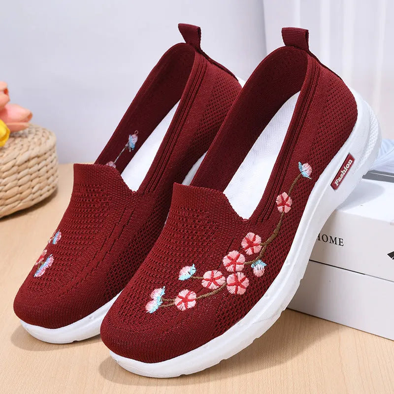 Women's black woven ballet pumps with floral embroidery and a flat anti-slip sole.