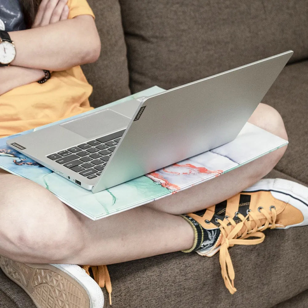 Durable heat-insulating anti-radiation laptop pad in black, black gold, blue, and green colour options on a desk.