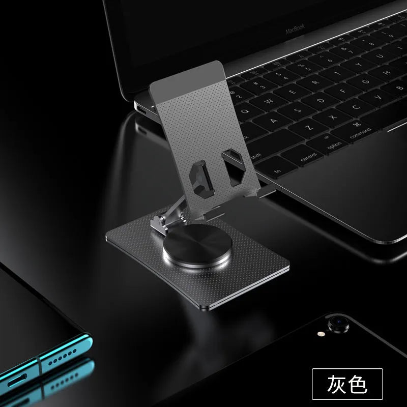 Aluminium alloy rotating mobile phone bracket in silver on a desk, showing three-axis joint and metal texture finish