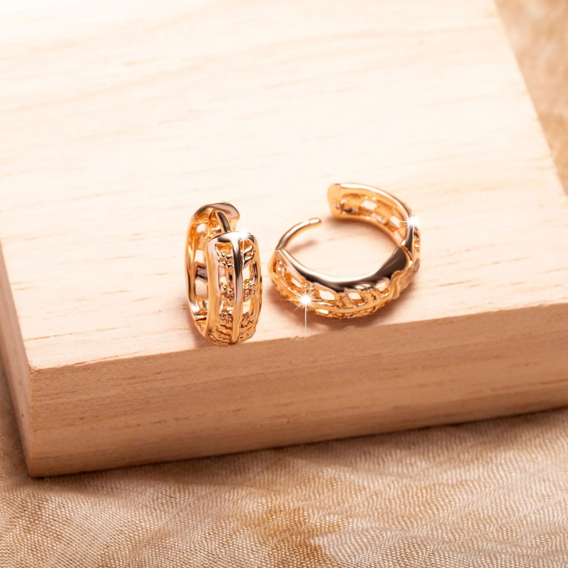 Rose gold hollowed-out heart and leaf shaped copper earrings on a white background, showing intricate cut-out details.