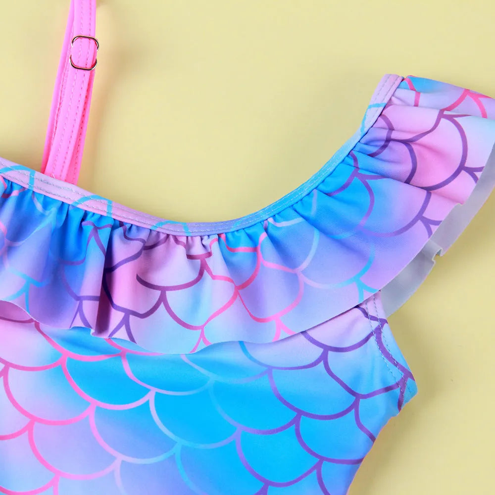 Girls' one-piece swimsuit with blue gradient fish scale print and flounced design.