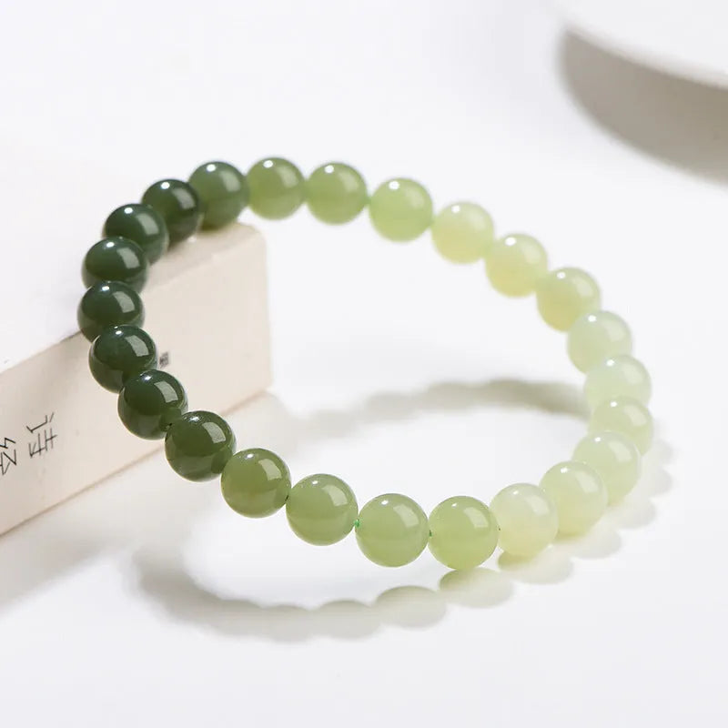 Natural clear water Hetian jade bracelet with gradient round beads on a wrist.