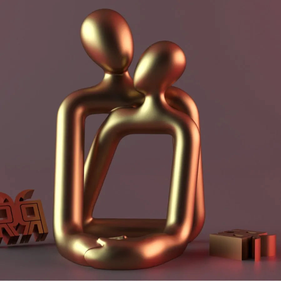 Modern minimalist resin statue of a couple in milky white or gold finish on a wooden surface.
