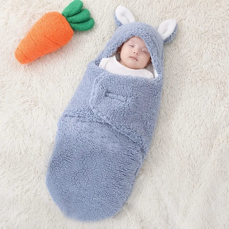 Baby wearing a grey adjustable fleece swaddle sleep sack with velcro wings