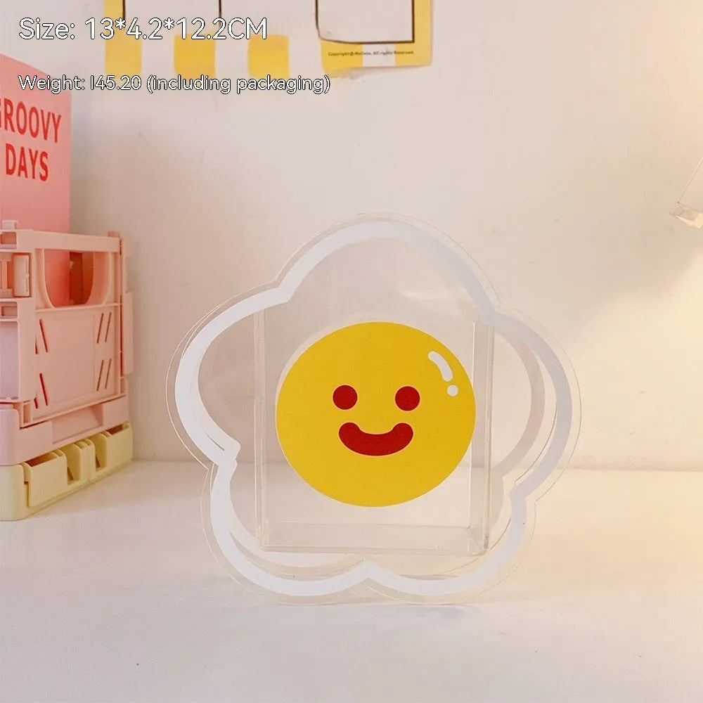 Square transparent acrylic storage box with a cute decorative design, shown on a desk.