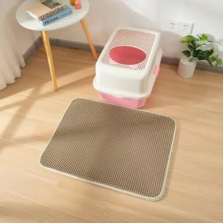 Black waterproof EVA cat litter mat with honeycomb surface for trapping litter, shown next to a litter box.