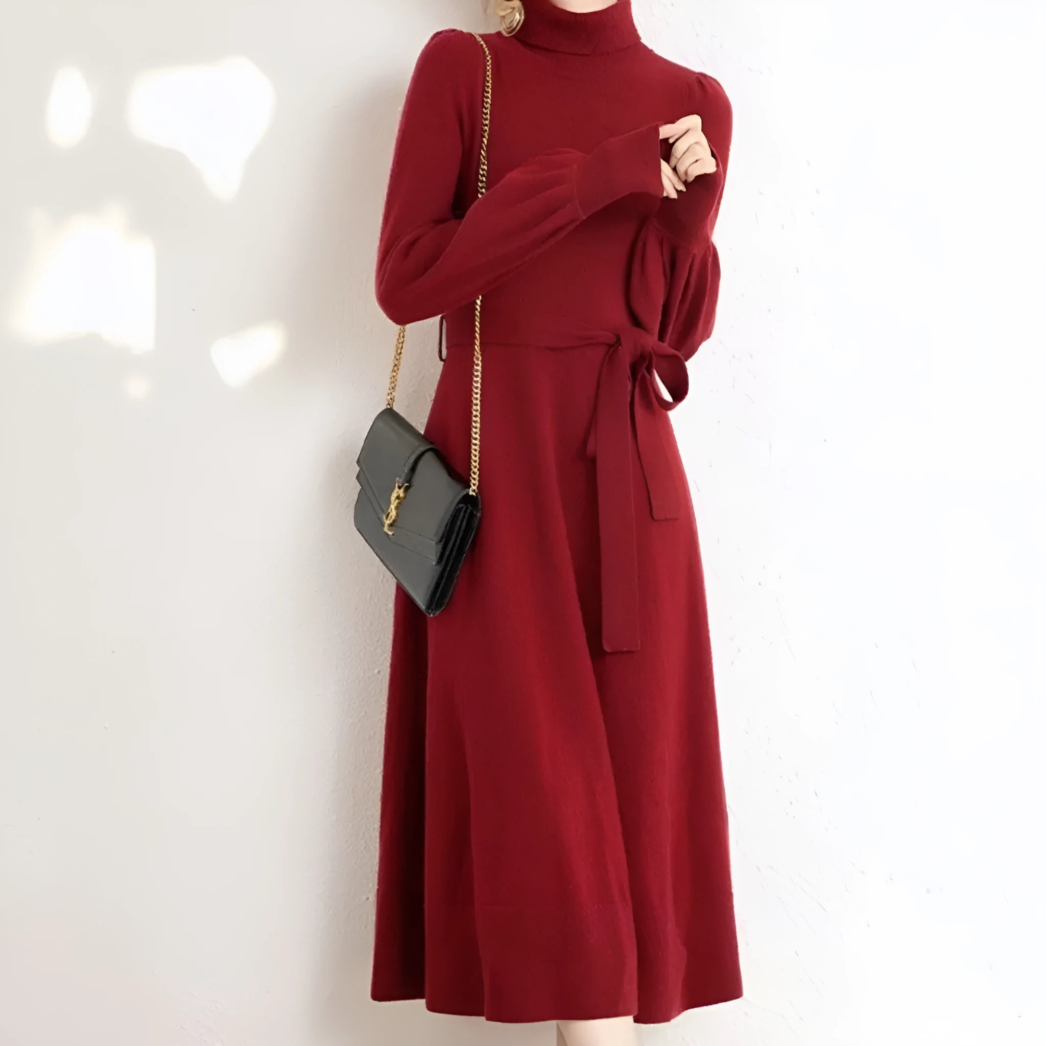 A rose red turtleneck knit dress with long sleeves, a loose hem, and an elastic waist on a hanger.