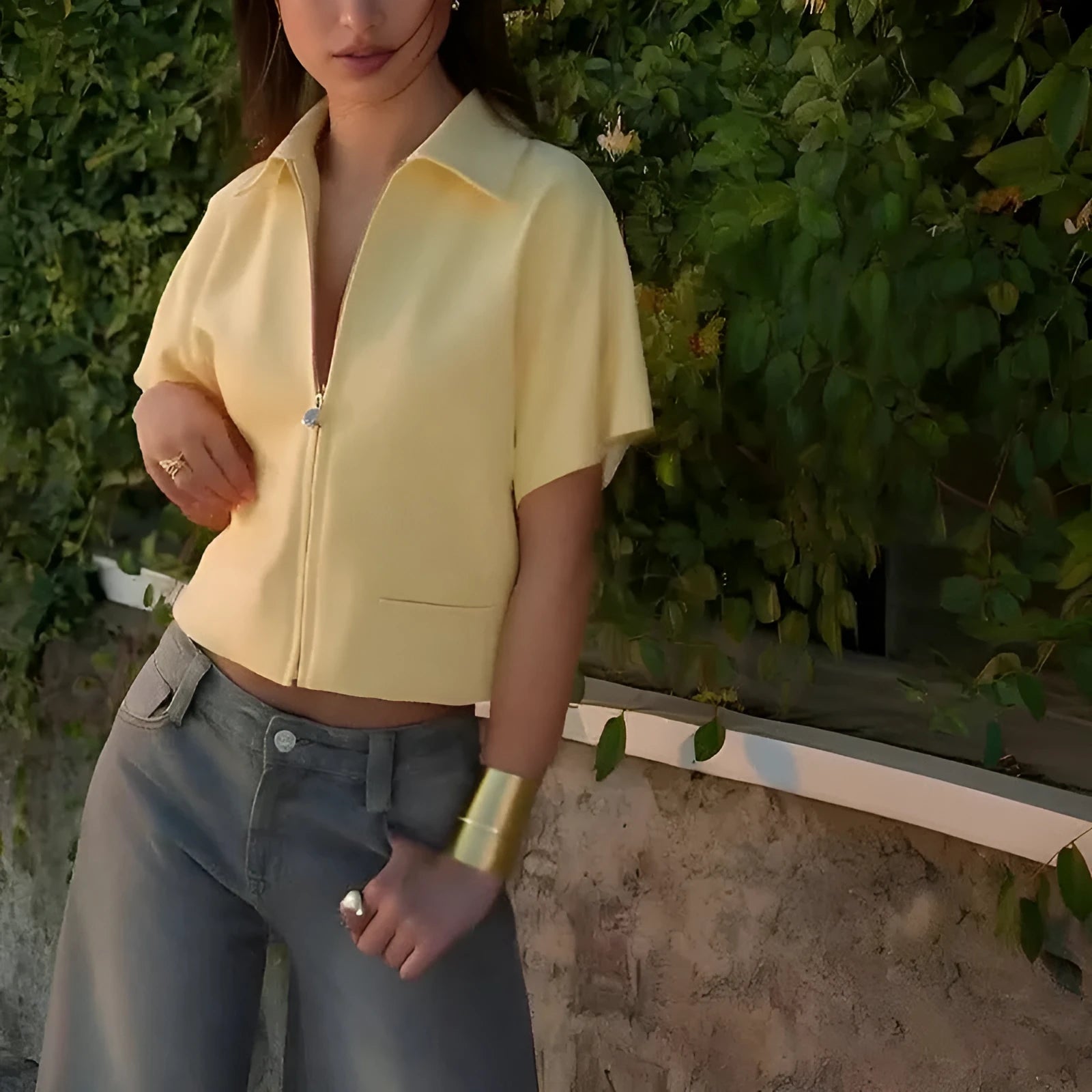 Man wearing a loose-fit yellow casual short-sleeve top on a neutral background.