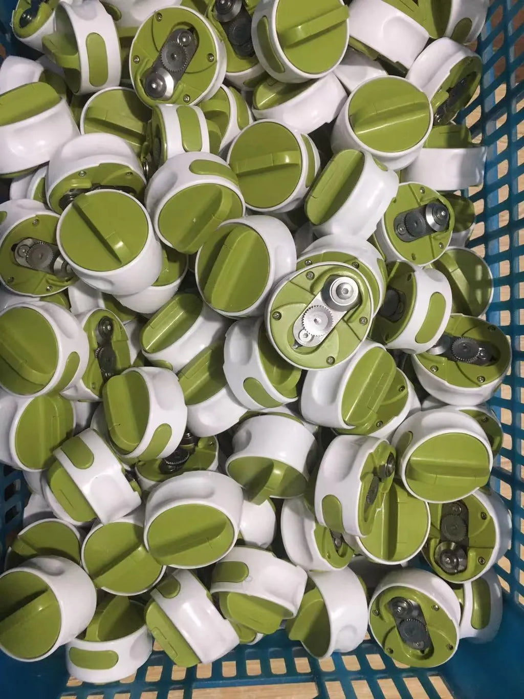 A green stainless steel manual bottle opener and lid removal tool on a kitchen counter.