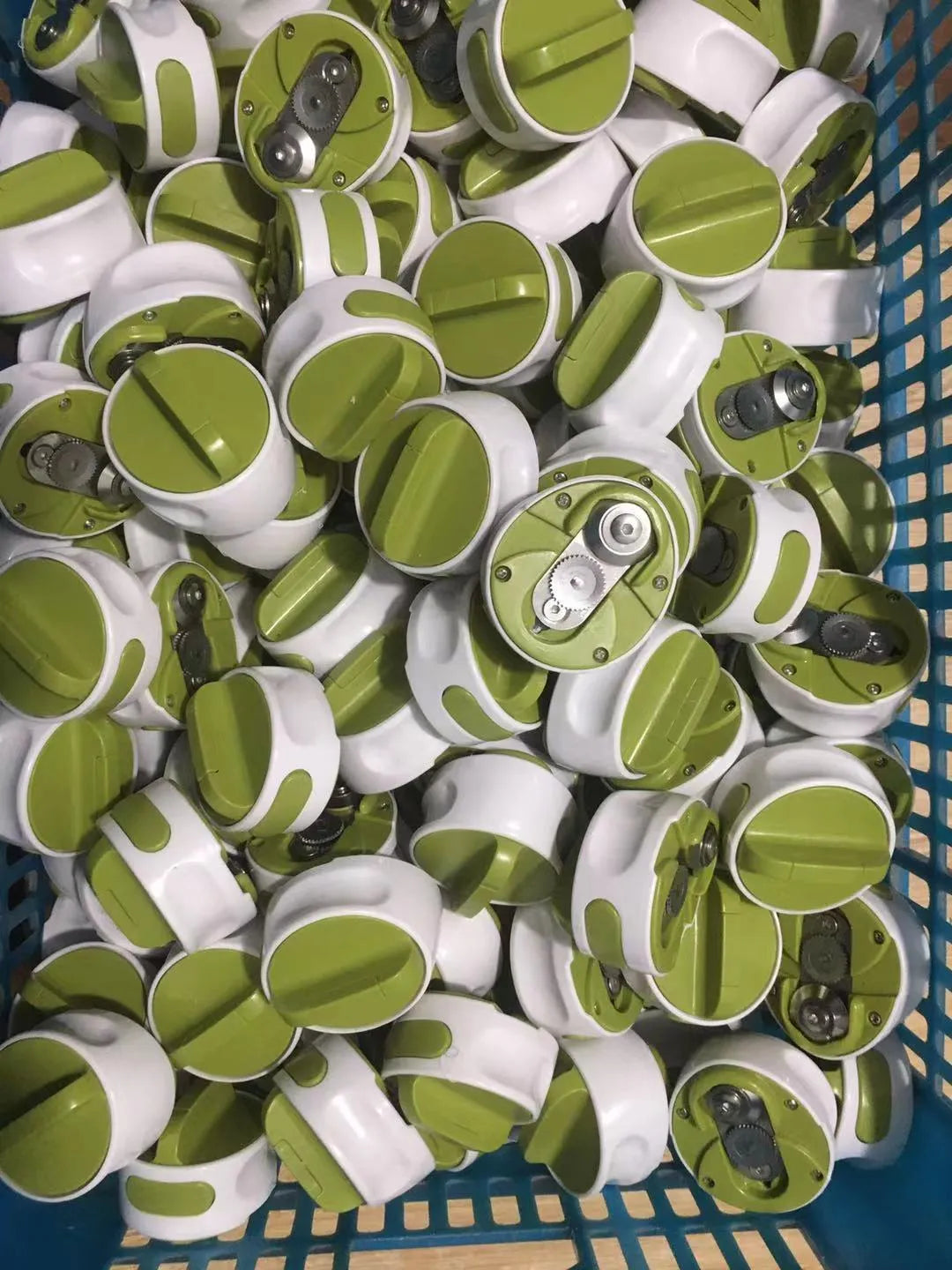 A green stainless steel manual bottle opener and lid removal tool on a kitchen counter.