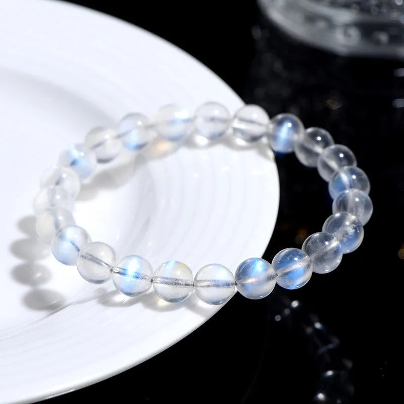 Natural blue moonlight crystal bracelet with cream body beads on a white background.