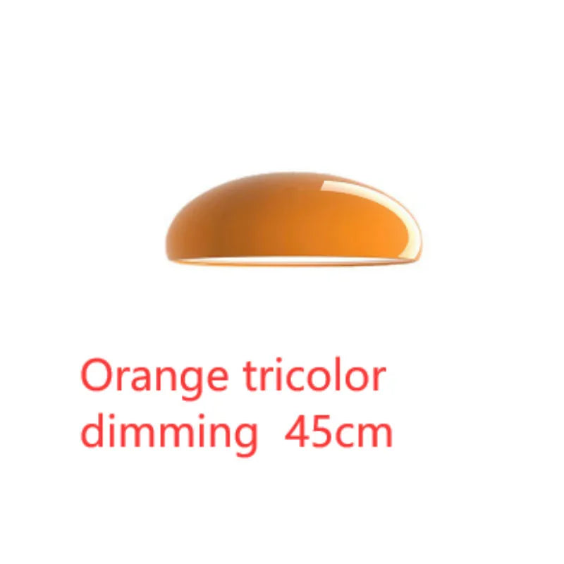 Orange iron Danish-style pendant lamp with adjustable cable above a restaurant table.