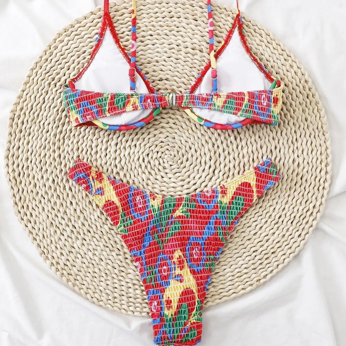 Red floral patterned women's underwire triangle bikini top and briefs on a mannequin.